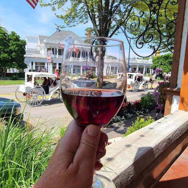Enjoying a glass of wine on the patio of Bavarian Inn Restaurant while watching a horse-drawn carriage go by in front of Zehnder's of Frankenmuth