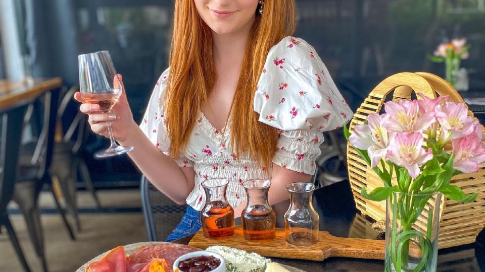 Woman at an outdoor patio table with a glass of wine and a charcuterie board at Prost Wine Bar & Charcuterie in Frankenmuth