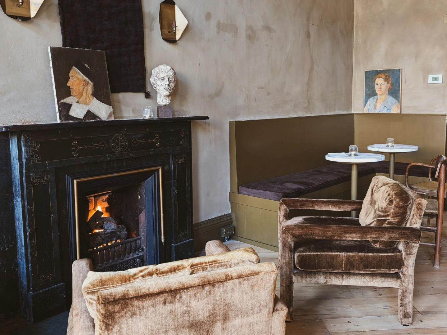 Views of a cozy seating area surrounding the fireplace at Neighbors Natural Wine and Bottle Shop in Downtown Bay City, Michigan