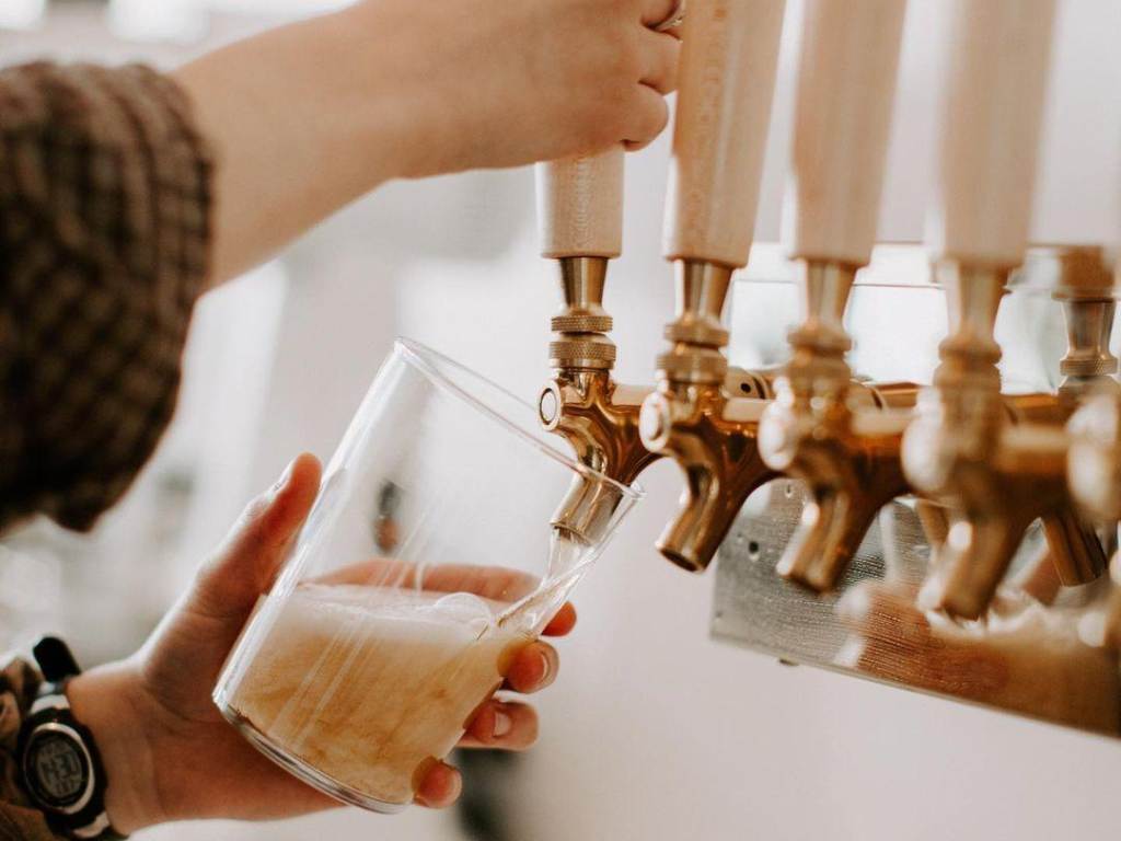 Beer being poured from a tap at Harless + Hugh Coffee in Bay City