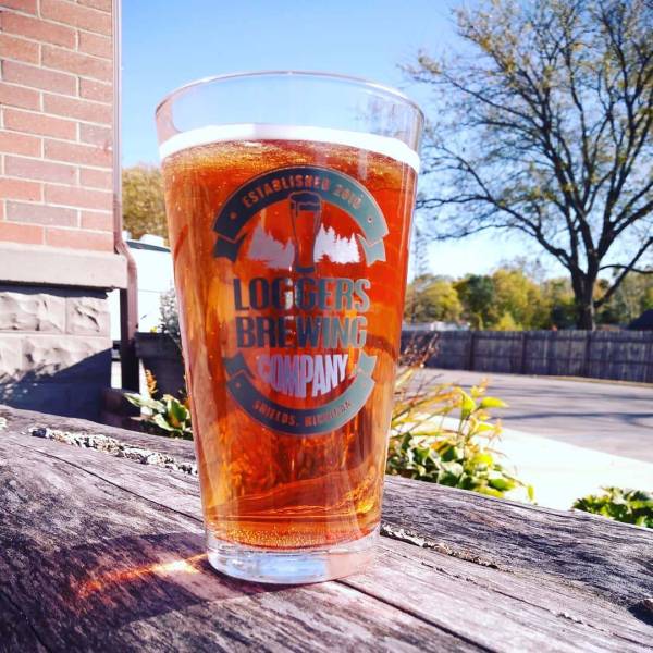Blueberry Sourtooth Ale served up in a pint glass on a picnic table outside Loggers Brewing Company in Sheilds