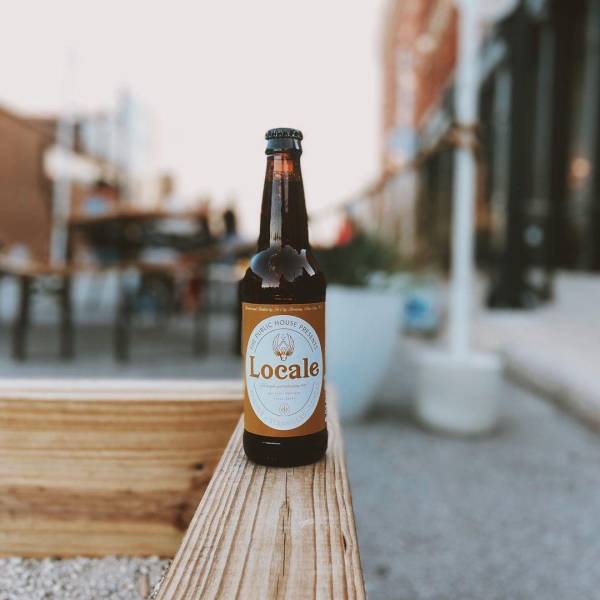 Locale beer on the ledge of a bocce ball court set up in the street in front of The Public House in Bay City