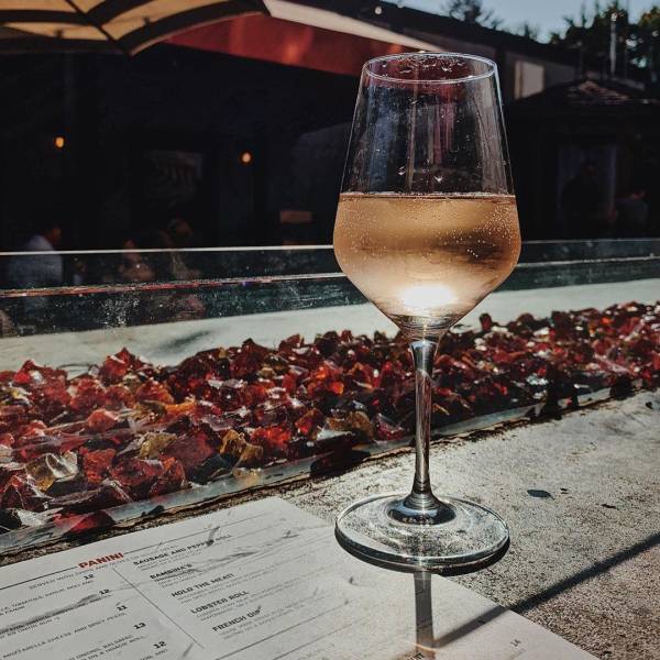 A glass of wine by the outdoor firebar on the patio of Prost Wine Bar & Charcuterie in Frankenmuth