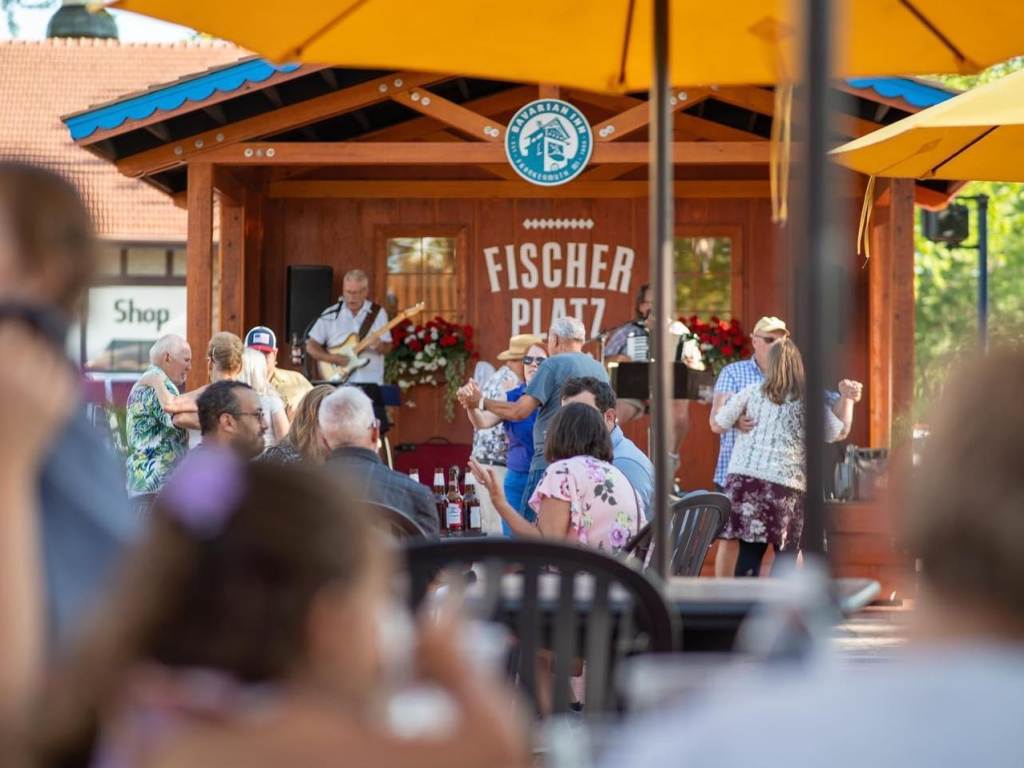 People enjoying German food & brews and dancing to live music at the outdoor music cafe & beer garden, Fischer Platz at the Bavarian Inn Restaurant in Frankenmuth