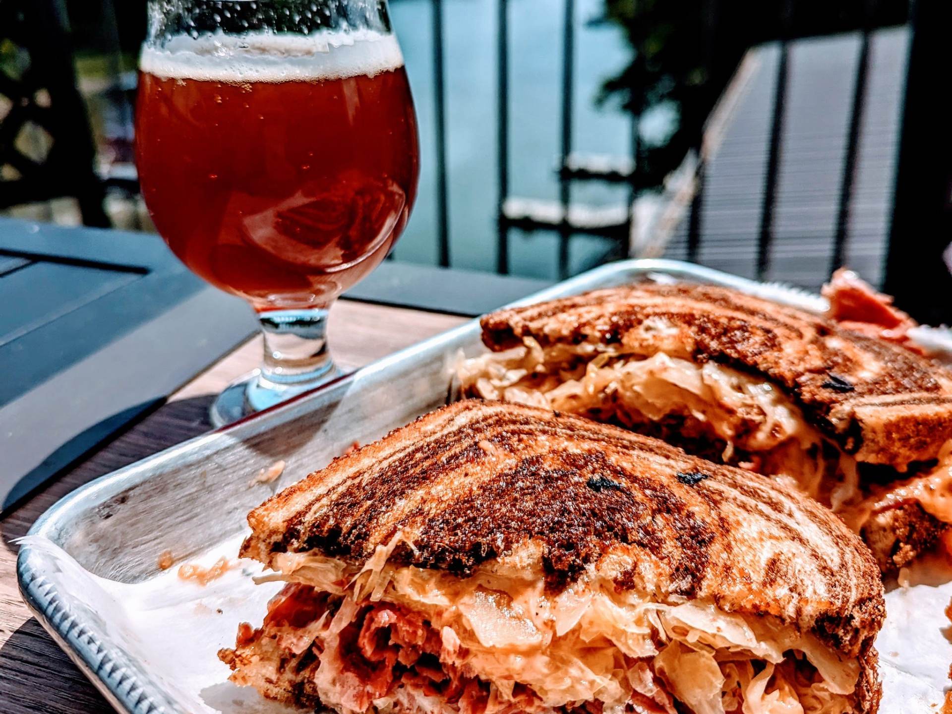 Brewben (reuben) sandwich and a beer on the outdoor decks of Frankenmuth Brewery in Frankenmuth, with views of the Cass River in the background