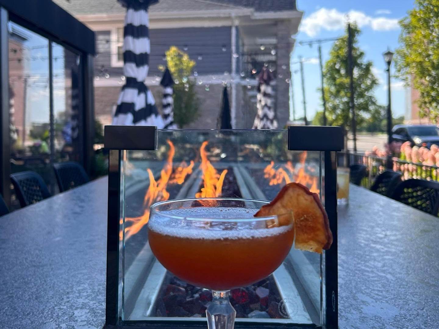 Views of a handcrafted fall cocktail by the outdoor fire bar at Prost! Wine Bar & Charcuterie in Bay City, Michigan.