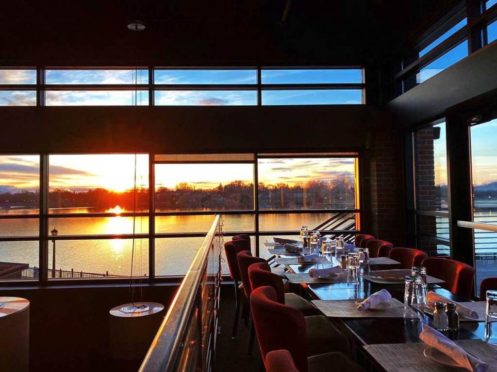 Views of the sun setting over the waterfront through a gorgeous wall of windows at Real Seafood Company Bay City