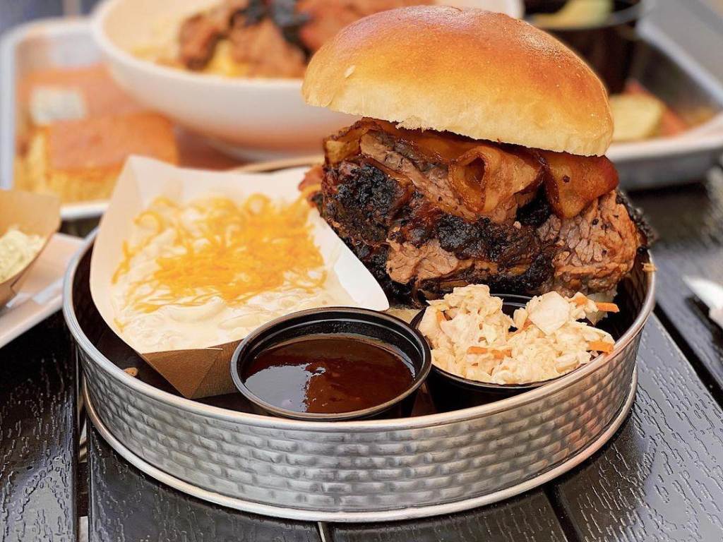 The Three Amigos: pork, brisket, and smoked bacon piled high on a soft bun at Molasses Smokehouse + Bar in Midland