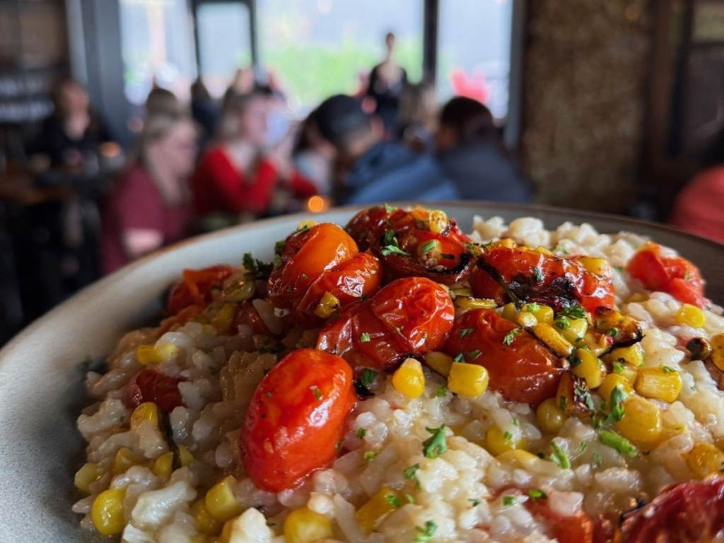 Views of a gorgeous plate of Tomato & Sweet Corn Risotto inside Prost! Wine Bar & Charcuterie in Uptown Bay City, Michigan.