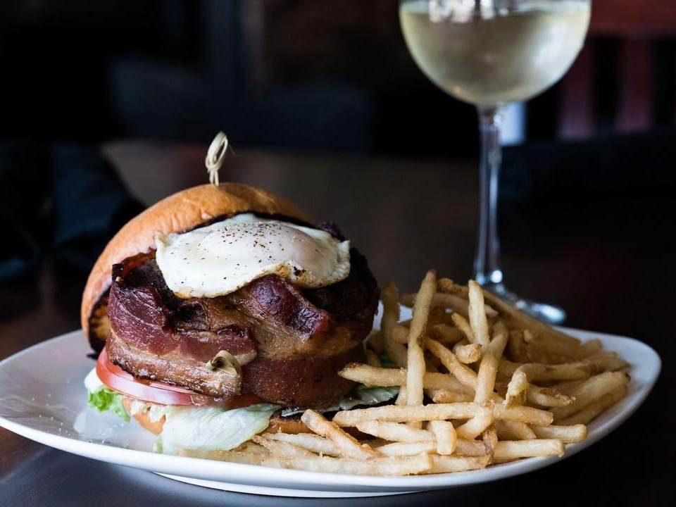 The "Juicy Jake" burger & fries, served with a glass of wine at Jake's Old City Grill in Saginaw