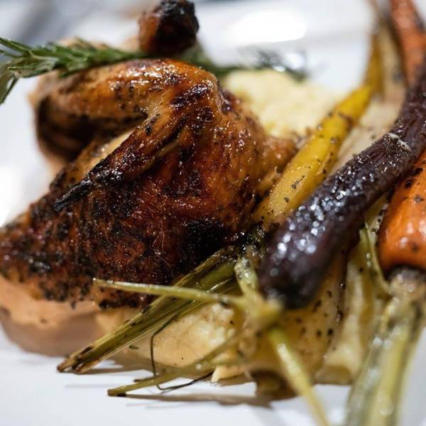 Roasted chicken and tri-colored carrots, perfectly plated at Artisan Urban Bistro in Old Town Saginaw