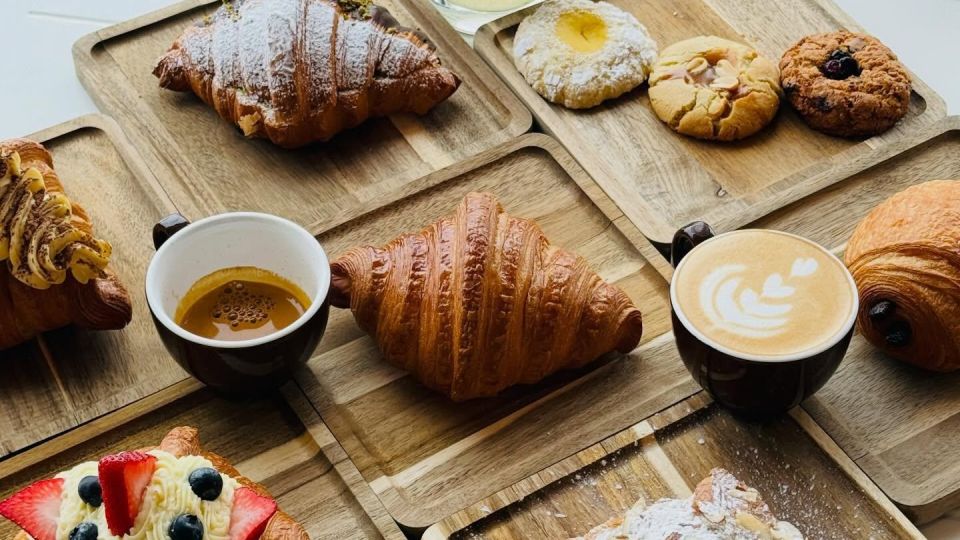 A beautiful spread of artisanal European pastries and specialty coffee beverages on a table at Chef Sergey's Bakery in Midland, Michigan.