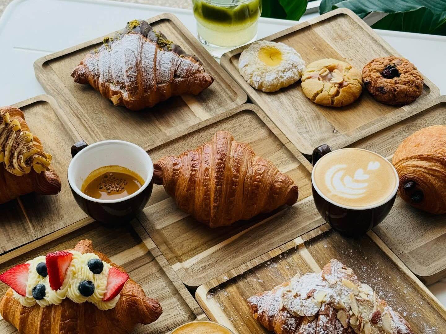 A beautiful spread of artisanal European pastries and specialty coffee beverages on a table at Chef Sergey's Bakery in Midland, Michigan.