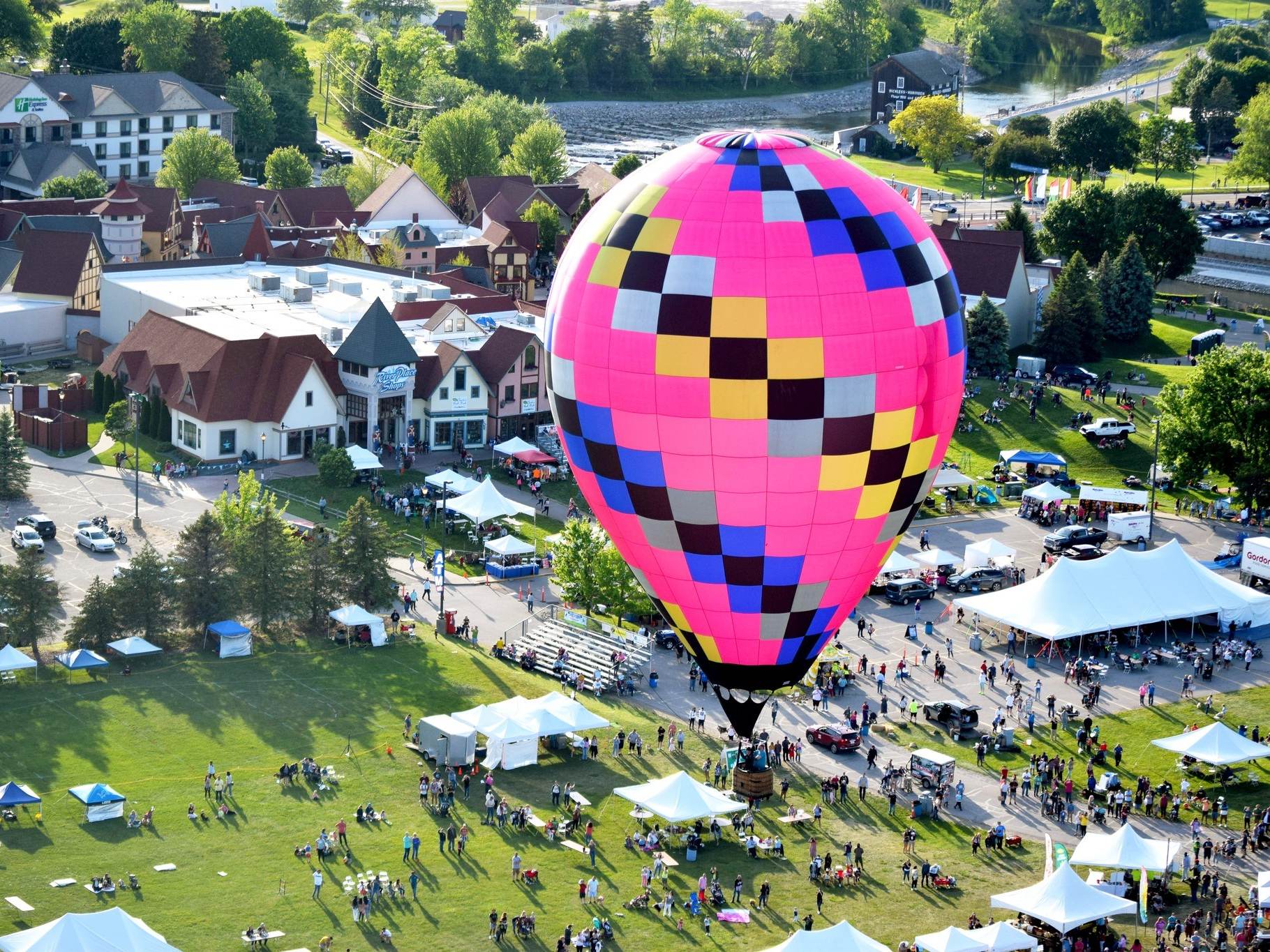A bright pink hot air balloon flying over the festival during Balloons Over Bavarian Inn in Frankenmuth