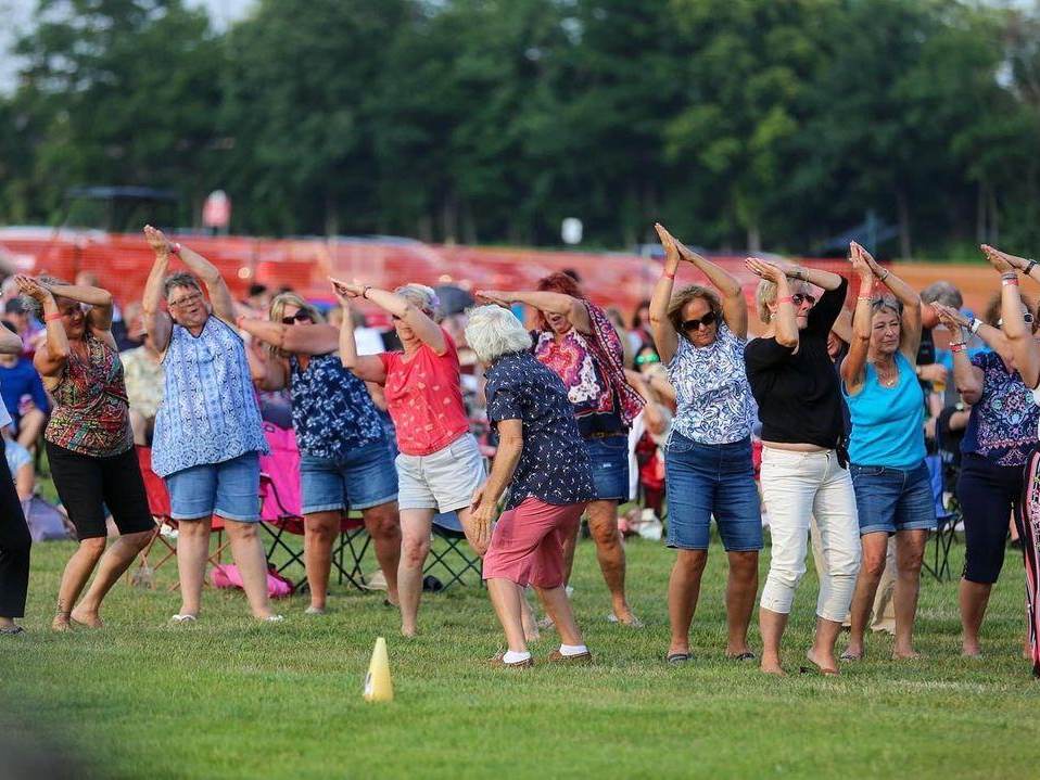 Crowd of people dancing on the lawns to live music during the Party on McCarty summer concert series in Saginaw