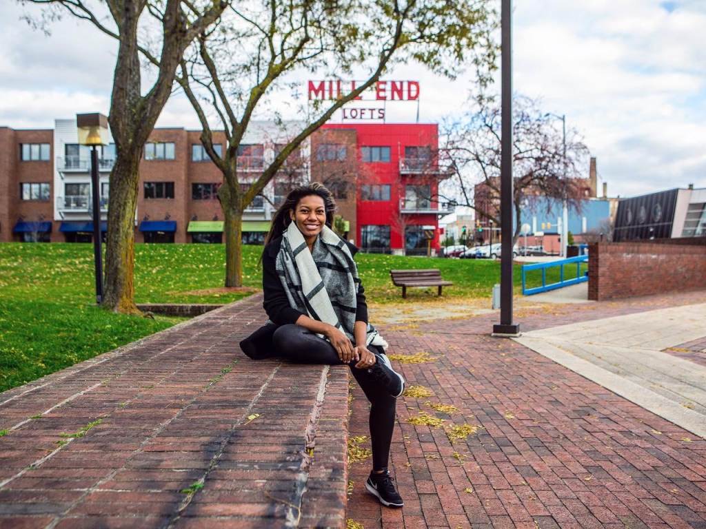 Woman sitting on brick bench surrounding the Friendship Ring at Wenonah Park in Downtown Bay City