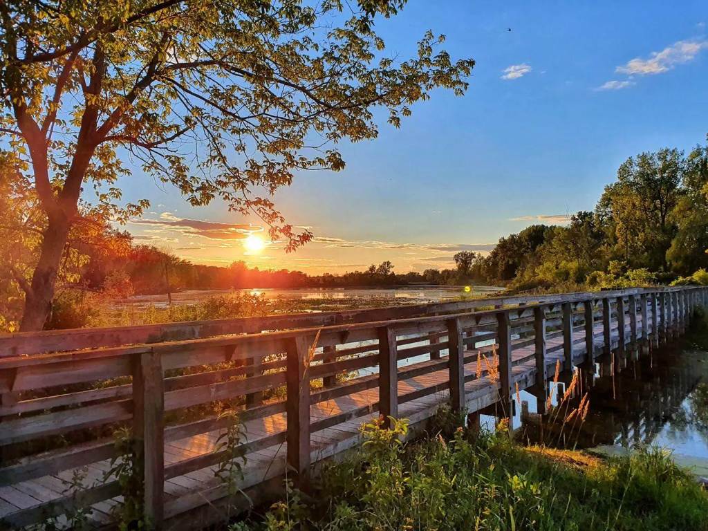 A beautiful sunset glistening over the waterfront boardwalk at Bay City State Park in Bay City