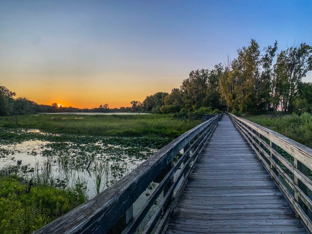 Views of a scenic boardwalk trail through Tobico Marsh at Bay City State Park in Bay City, Michigan at sunset