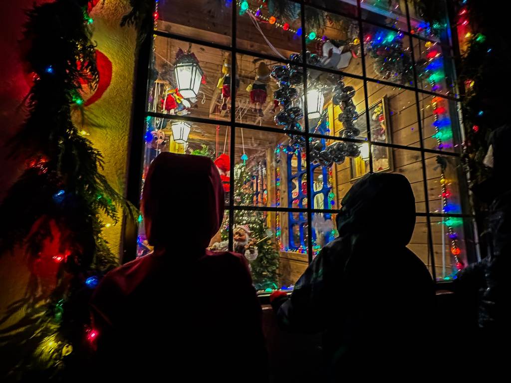 Kids peering through the window into the festively decorated and lighted Midland Santa House in Midland, Michigan