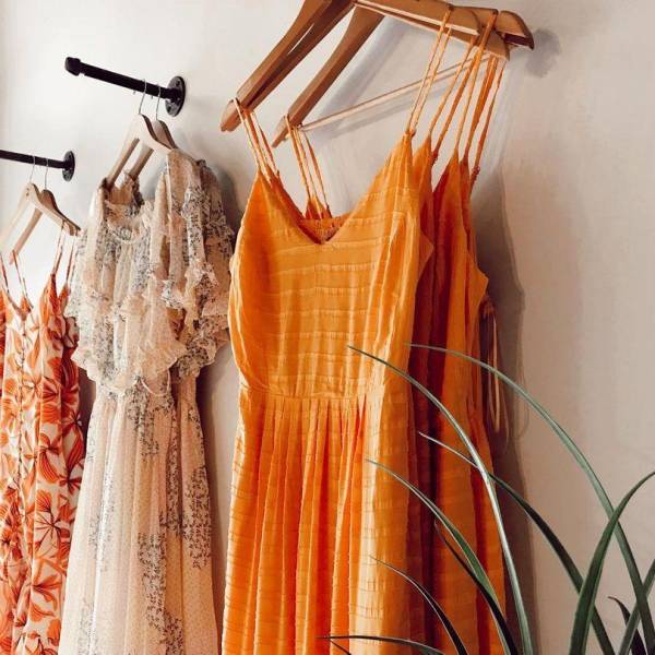 Colorful lineup of spring and summer dresses displayed on the wall of Ferne Boutique in Bay City