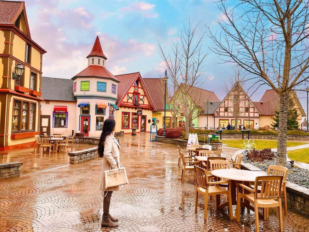 A person standing on the cobblestone paths of Frankenmuth River Place Shops in Frankenmuth, pondering which store to pop into next