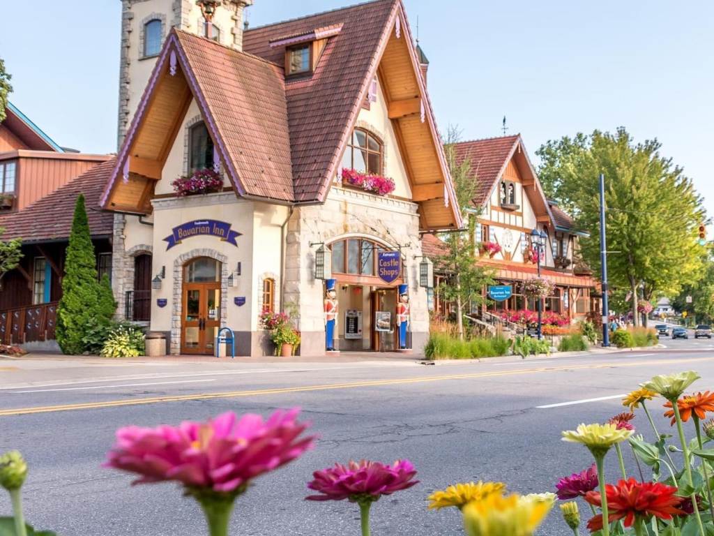 A roadside picture of the charming Bavarian Inn Castle Shops in Frankenmuth, with colorful spring flowers popping up in the foreground