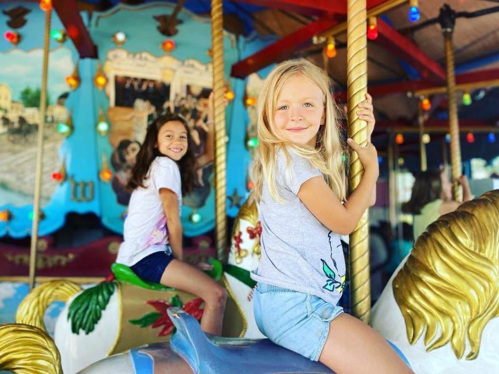 Two girls on the hand-carved carousel at the Saginaw Children's Zoo in Saginaw