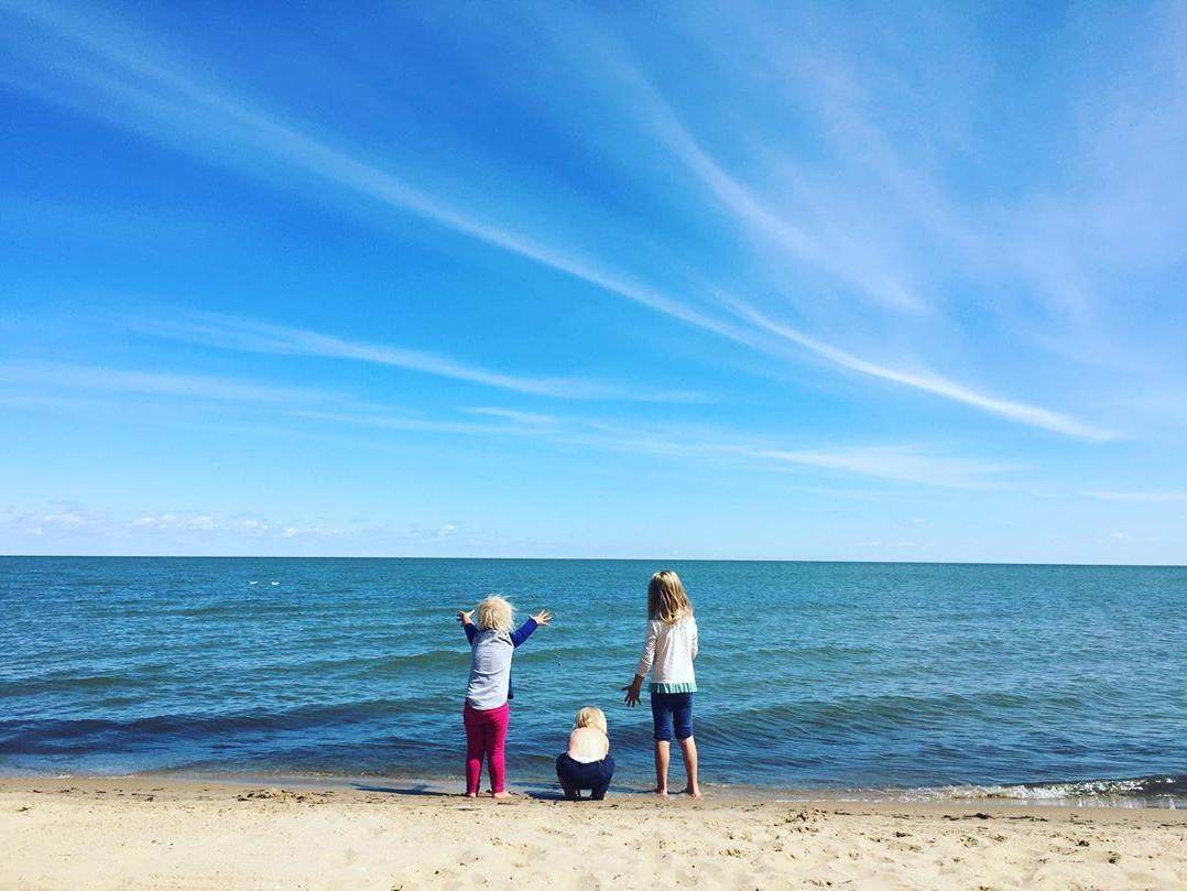 Kids looking out at the water from the sandy beach at Bay City State Park