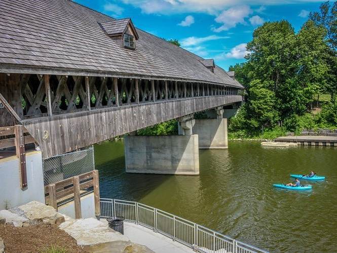 Kayakers about to paddle underneath the Bavarian Inn Holz Brücke covered wooden bridge in Frankenmuth